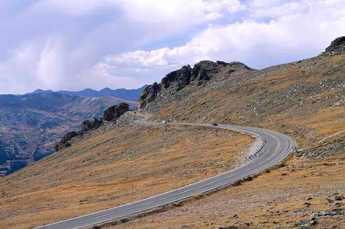 Scenic view of a winding road through a mountainous landscape, highlighting legendary American road routes.