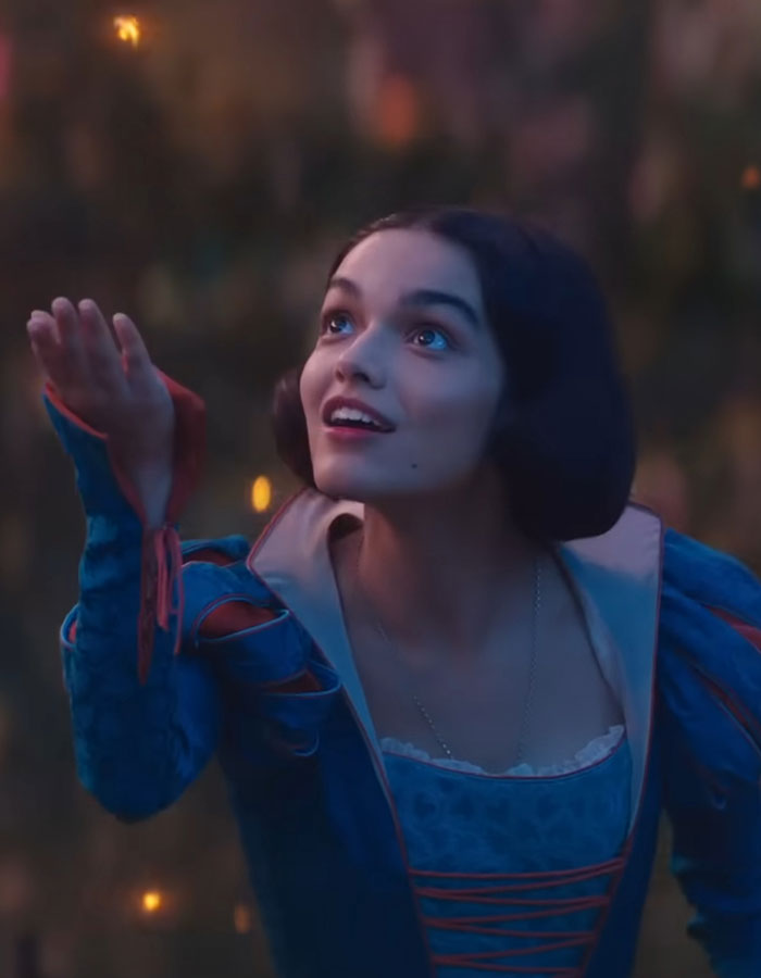 Young woman in a blue costume reaching out with an expression of wonder. Young woman in a blue costume reaching out with an expression of wonder.