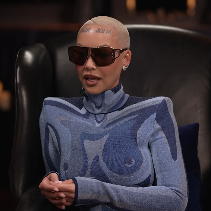 Amber Rose in an abstract-patterned outfit and sunglasses, seated, discussing Kanye West's views on provocative fashion. Amber Rose in an abstract-patterned outfit and sunglasses, seated, discussing Kanye West's views on provocative fashion.