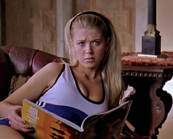 Blonde woman reading a magazine, wearing a white tank top, sitting on a sofa, scene from a movie. Blonde woman reading a magazine, wearing a white tank top, sitting on a sofa, scene from a movie.