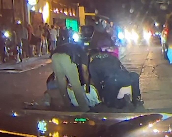 Police arrest convict after assault at bachelorette party, street scene with crowd and flashing lights. Police arrest convict after assault at bachelorette party, street scene with crowd and flashing lights.