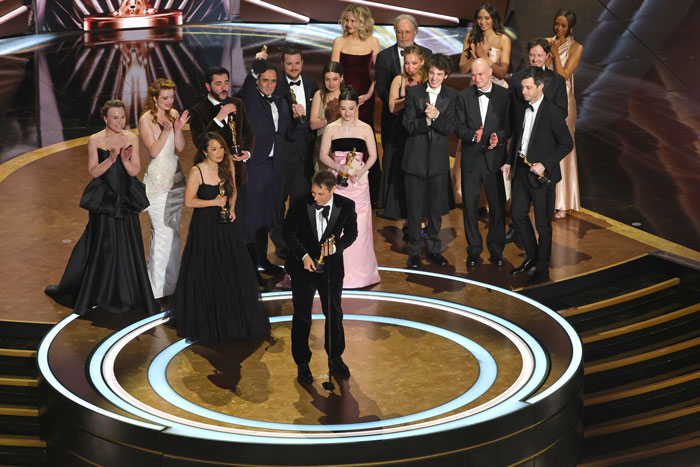 Winners celebrating on stage at the Oscars 2025, holding their awards and smiling. Winners celebrating on stage at the Oscars 2025, holding their awards and smiling.