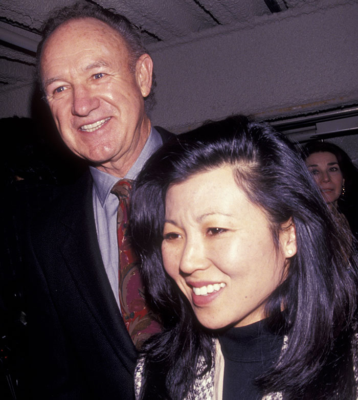 A man and woman smiling at an event, related to deepening Gene Hackman mystery. A man and woman smiling at an event, related to deepening Gene Hackman mystery.