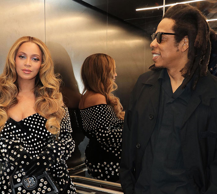 Beyoncé and Jay-Z in an elevator, Beyoncé wearing a studded outfit, Jay-Z smiling in a black jacket and sunglasses. Beyoncé and Jay-Z in an elevator, Beyoncé wearing a studded outfit, Jay-Z smiling in a black jacket and sunglasses.