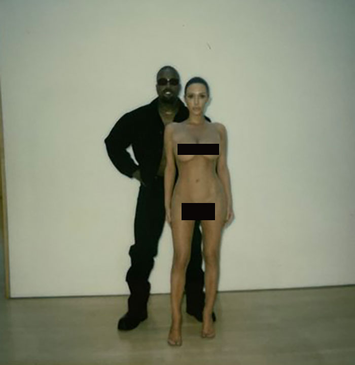 Blonde woman posing for a photo shoot with a man in black clothing, minimalist setting. Blonde woman posing for a photo shoot with a man in black clothing, minimalist setting.