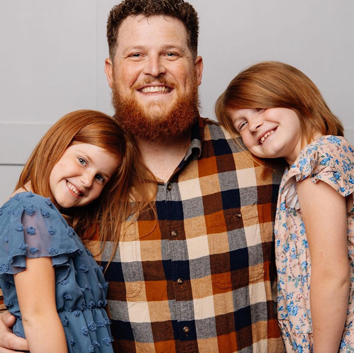 Smiling family portrait with two girls and a man in plaid shirt, related to a tragic incident involving a 'monster' mom. Smiling family portrait with two girls and a man in plaid shirt, related to a tragic incident involving a 'monster' mom.