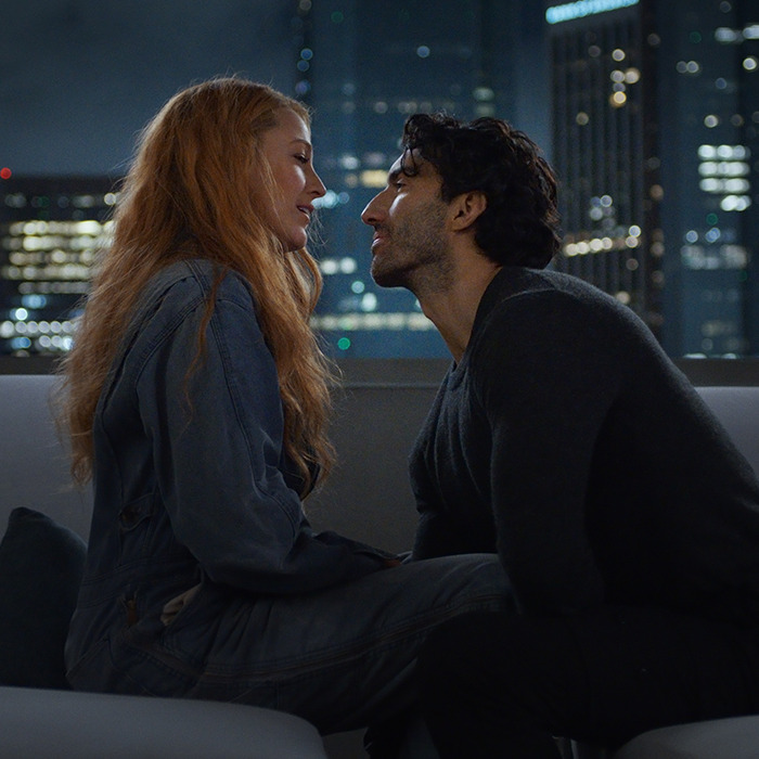 Two people seated closely on a rooftop at night, city skyline in the background, sparking buzz. Two people seated closely on a rooftop at night, city skyline in the background, sparking buzz.