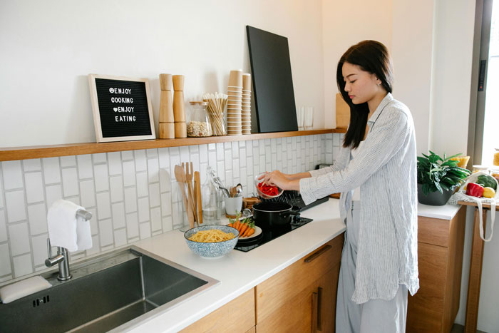 Woman cooking in kitchen with ingredients, contemplating a boyfriend confrontation. Woman cooking in kitchen with ingredients, contemplating a boyfriend confrontation.