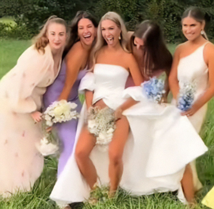 Bride flashes underwear with bridesmaids during wedding photoshoot in a playful outdoor setting. Bride flashes underwear with bridesmaids during wedding photoshoot in a playful outdoor setting.