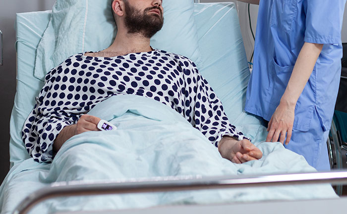 Man in hospital bed with nurse, illustrating concept of choosing a female friend over the long-term girlfriend for wedding invitation. Man in hospital bed with nurse, illustrating concept of choosing a female friend over the long-term girlfriend for wedding invitation.