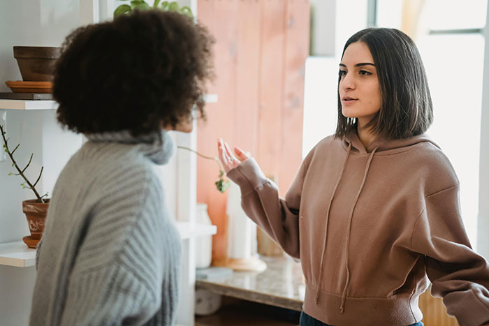 Woman discussing with another person in a kitchen, addressing an unexpected situation involving a brother's girlfriend. Woman discussing with another person in a kitchen, addressing an unexpected situation involving a brother's girlfriend.