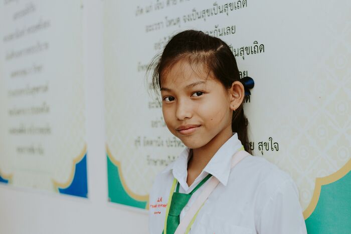 Young student standing in front of a poster, related to ridiculous bullying stories.