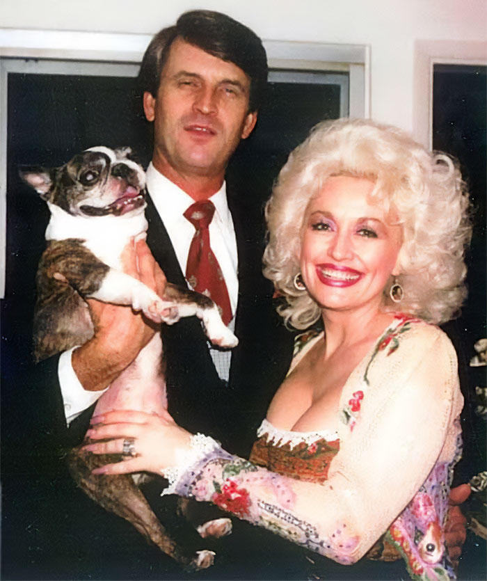 Dolly Parton smiling with a man and a dog, celebrating their laundromat love story. Dolly Parton smiling with a man and a dog, celebrating their laundromat love story.