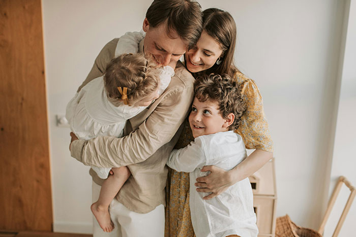 A happy family embracing, illustrating a "happily ever after" moment together in a bright home setting. A happy family embracing, illustrating a "happily ever after" moment together in a bright home setting.