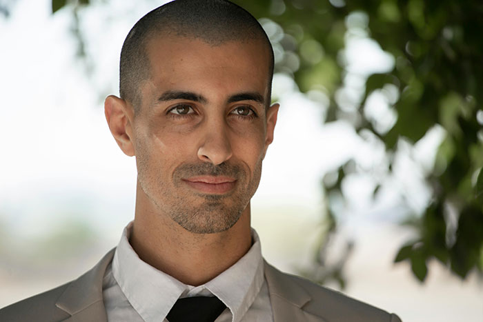 Man outdoors in a light suit, looking contemplative, with trees in the background, representing affair partners narrative. Man outdoors in a light suit, looking contemplative, with trees in the background, representing affair partners narrative.