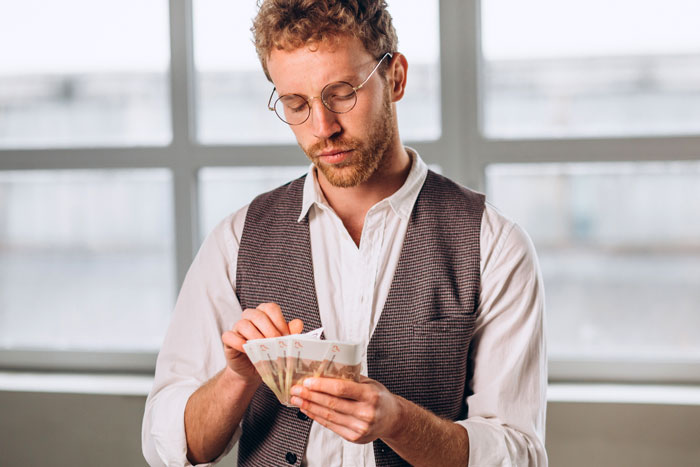 Man counting money, symbolizing high-value auction purchase of Pokémon-shaped Cheeto. Man counting money, symbolizing high-value auction purchase of Pokémon-shaped Cheeto.