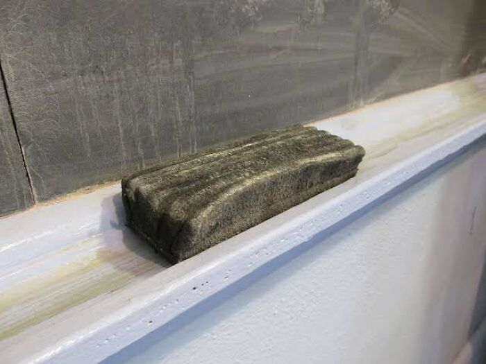 Chalkboard eraser on a ledge, ready for harmless April Fools’ pranks in a classroom setting.