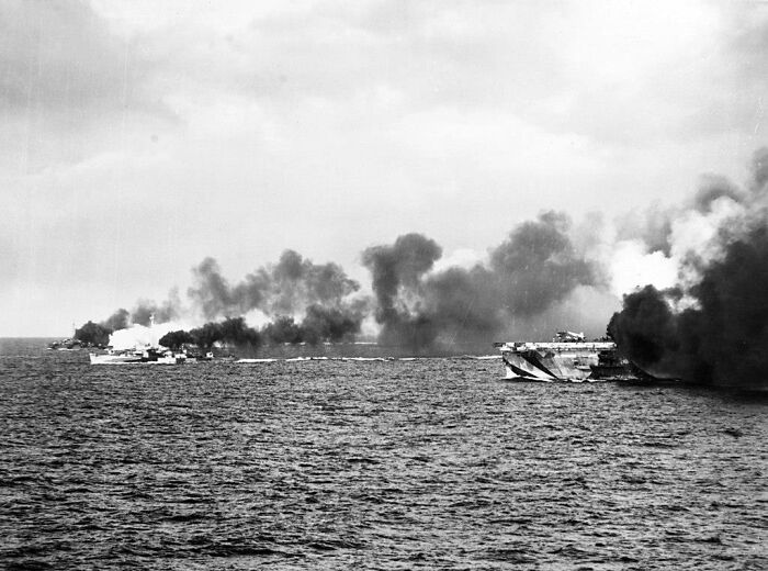 Smoke rises from naval ships during a sea battle, illustrating a dramatic historical event.
