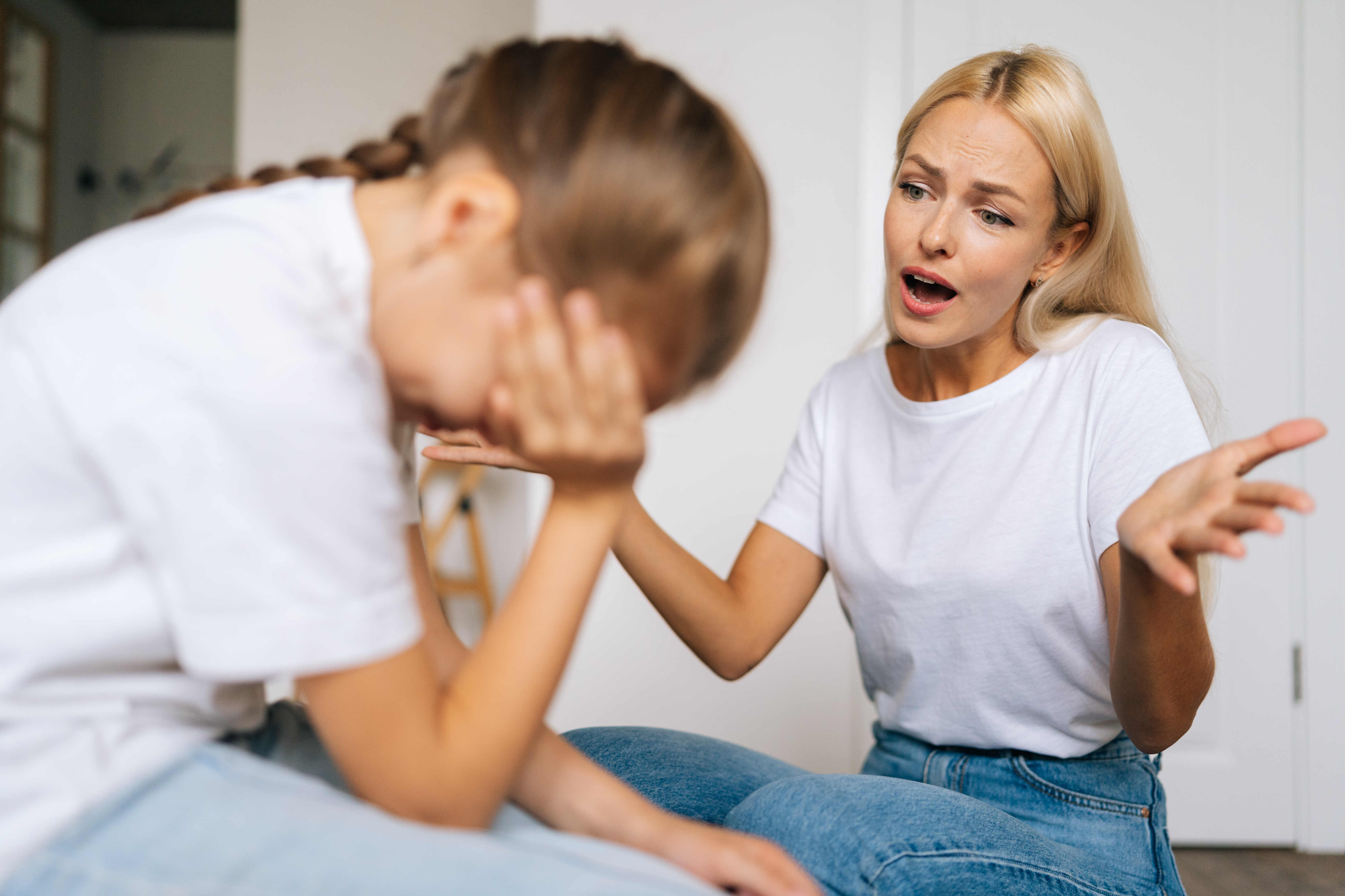 Mom consoling daughter, upset over being excluded from classmates' events. Mom consoling daughter, upset over being excluded from classmates' events.