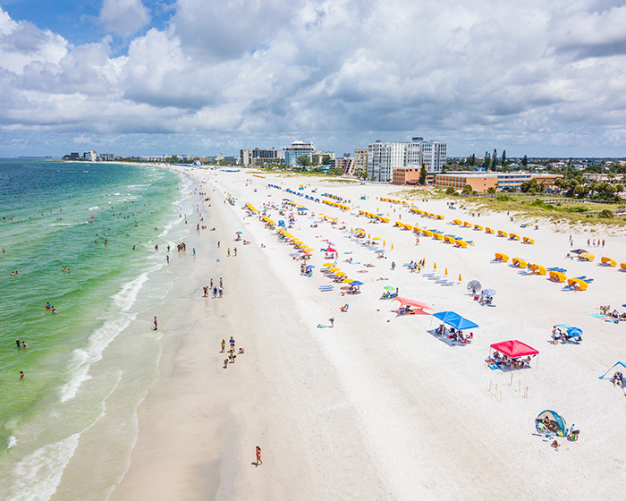 Aerial view of a crowded family swimming spot with people enjoying the beach and sea. Aerial view of a crowded family swimming spot with people enjoying the beach and sea.