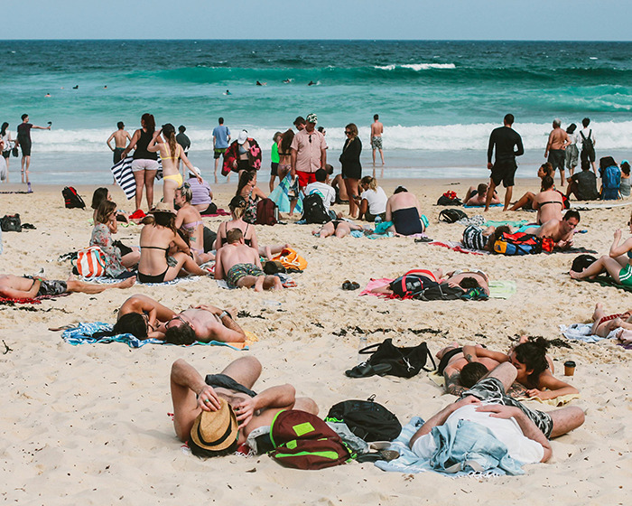 Beachgoers enjoying a sunny day at a crowded family swimming spot. Beachgoers enjoying a sunny day at a crowded family swimming spot.