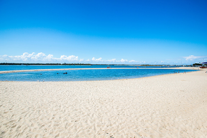 Sandy beach with a calm family swimming area under a clear blue sky. Sandy beach with a calm family swimming area under a clear blue sky.