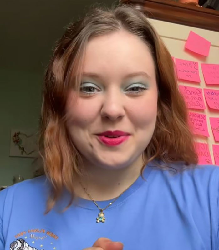 Young woman smiling in front of a wall with sticky notes, discussing her NASA astronaut father's health concerns. Young woman smiling in front of a wall with sticky notes, discussing her NASA astronaut father's health concerns.