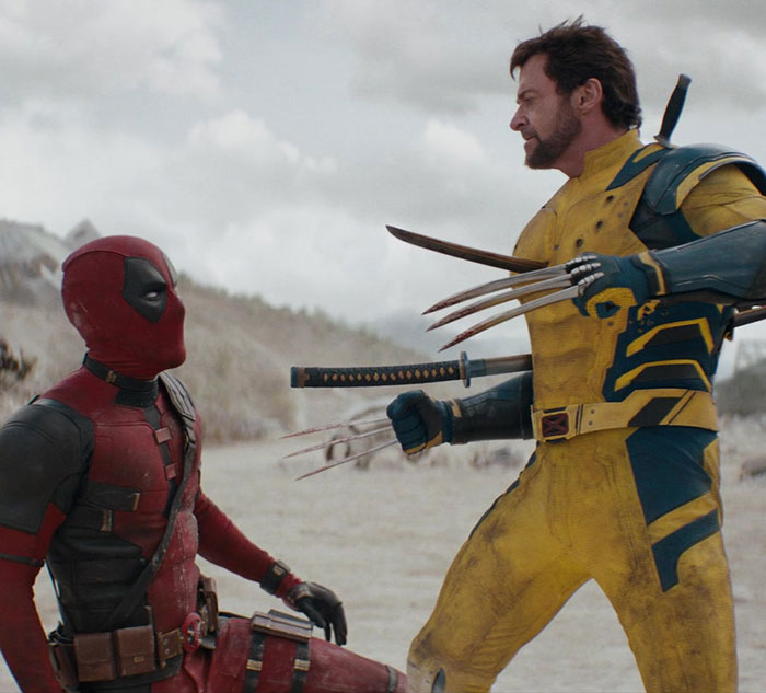 Hugh Jackman in Wolverine costume, confronting Deadpool in a snowy landscape. Hugh Jackman in Wolverine costume, confronting Deadpool in a snowy landscape.