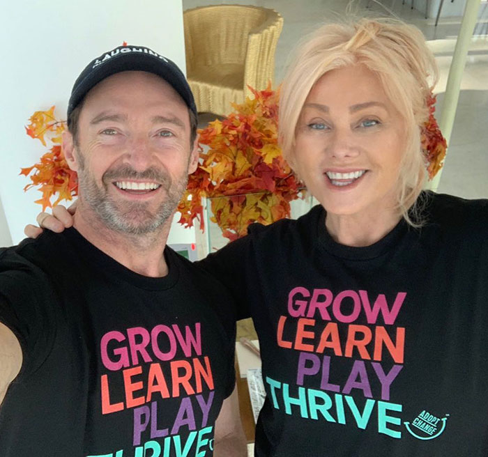 Smiling couple in matching shirts with autumn leaves; Hugh Jackman and Deborra-Lee divorce news context. Smiling couple in matching shirts with autumn leaves; Hugh Jackman and Deborra-Lee divorce news context.