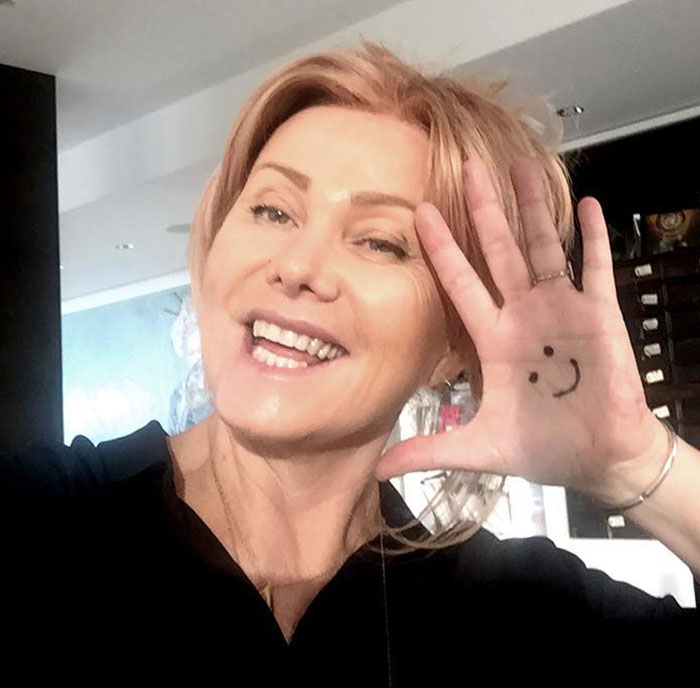 Smiling woman with a smiley face drawn on her hand; related to Hugh Jackman and Deborra-Lee Furness' divorce issues. Smiling woman with a smiley face drawn on her hand; related to Hugh Jackman and Deborra-Lee Furness' divorce issues.