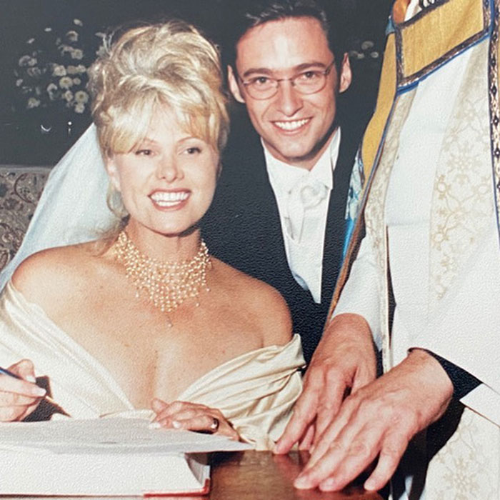 A bride and groom sitting together, smiling on their wedding day, as the bride signs a document. A bride and groom sitting together, smiling on their wedding day, as the bride signs a document.