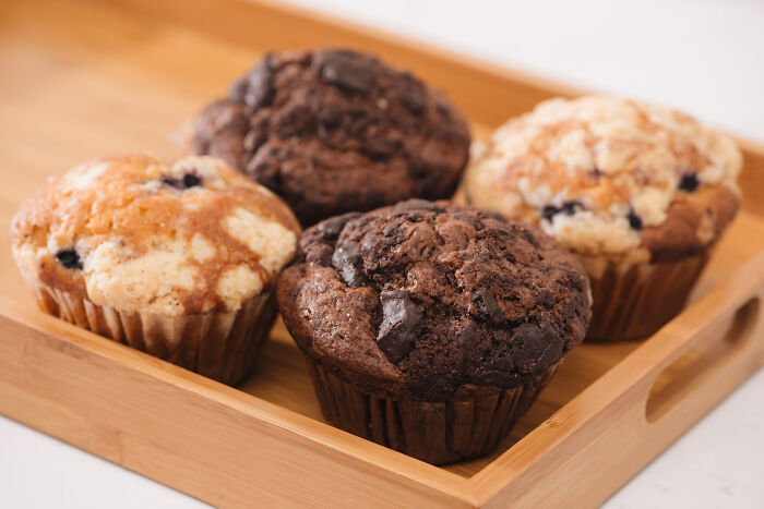 Assorted muffins on a wooden tray, representing misunderstood healthy snacks.