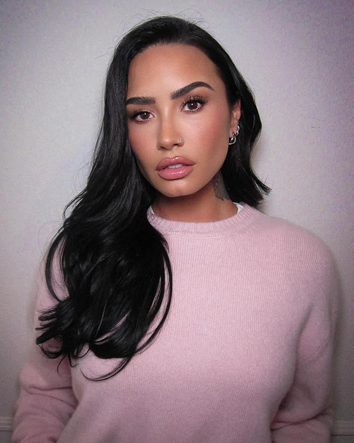 Woman in pink sweater showcasing weight loss transformation with long black hair against a plain background. Woman in pink sweater showcasing weight loss transformation with long black hair against a plain background.