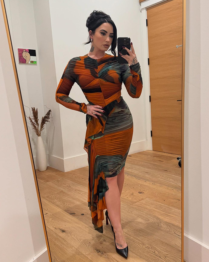 Person in elegant attire taking a mirror selfie, showcasing a weight loss transformation. Person in elegant attire taking a mirror selfie, showcasing a weight loss transformation.