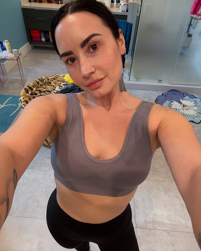 Demi Lovato showcases weight loss transformation in a gray top, standing in a stylish bathroom. Demi Lovato showcases weight loss transformation in a gray top, standing in a stylish bathroom.