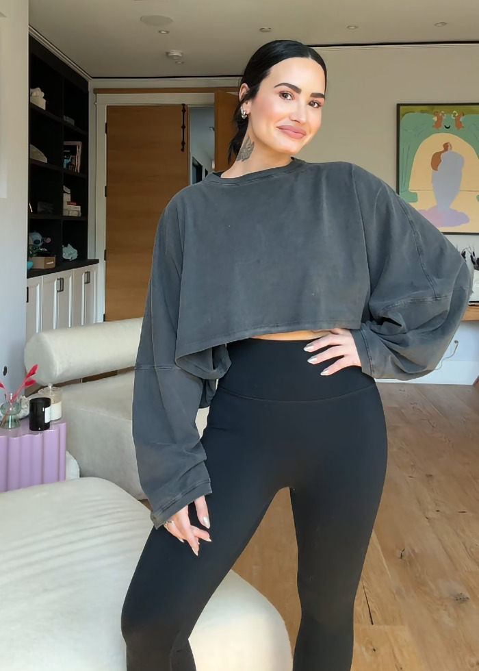 Demi Lovato shows weight loss transformation, wearing a loose-fitting sweatshirt and black leggings in a stylish room. Demi Lovato shows weight loss transformation, wearing a loose-fitting sweatshirt and black leggings in a stylish room.