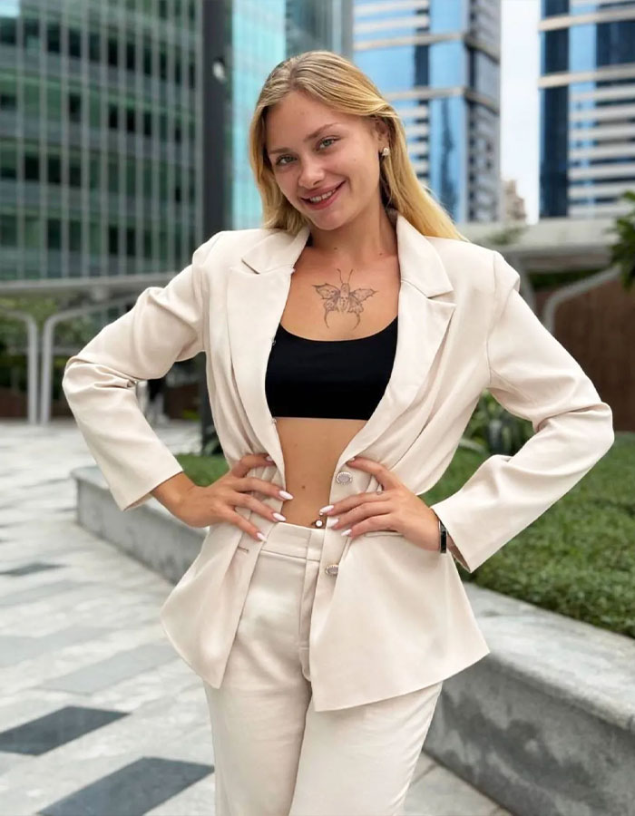 Model in a light suit smiling in a Dubai urban setting. Model in a light suit smiling in a Dubai urban setting.