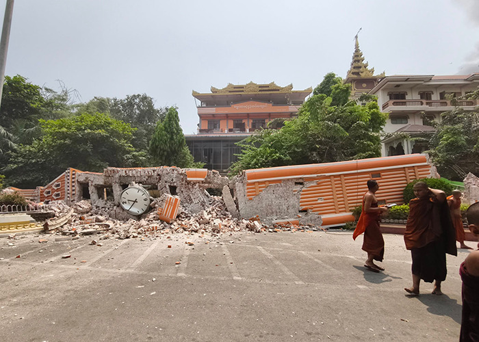 Buddhist monks walking past a collapsed building in Myanmar after an earthquake. Buddhist monks walking past a collapsed building in Myanmar after an earthquake.