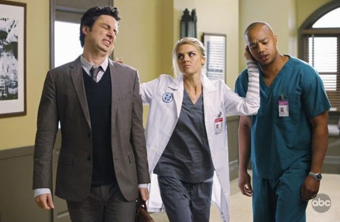 Actors from 'Scrubs' in a hospital scene, featuring a doctor and nurse interacting with a man in a suit. Actors from 'Scrubs' in a hospital scene, featuring a doctor and nurse interacting with a man in a suit.