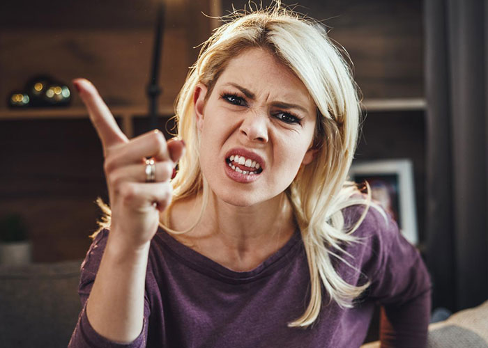 A step-mom with a frustrated expression points her finger, highlighting a tense family moment. A step-mom with a frustrated expression points her finger, highlighting a tense family moment.