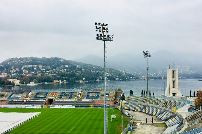 Soccer stadium with floodlights near a lakeside town, one of the cathedrals of soccer where legends are born.