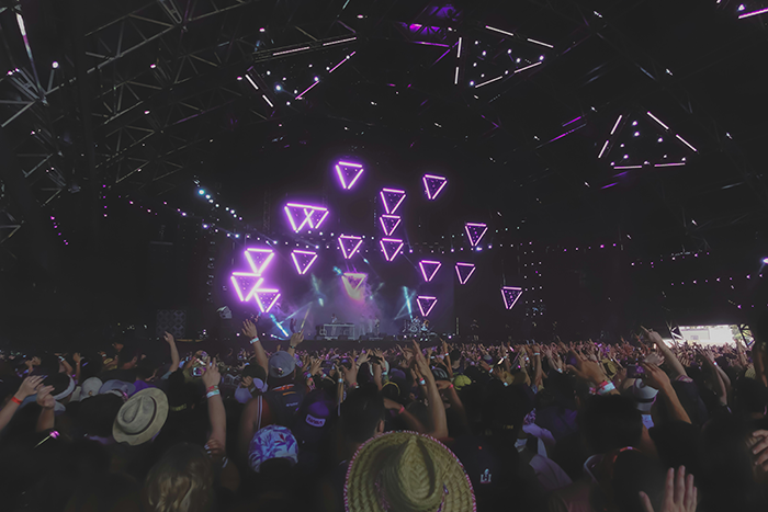 Concert crowd under a canopy of neon lights and geometric patterns. Concert crowd under a canopy of neon lights and geometric patterns.