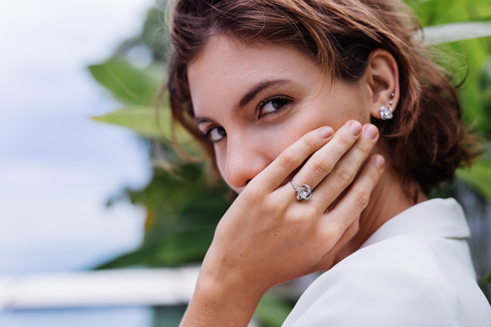 Woman displaying a ring, covering her mouth with a hand, symbolizing a reaction to a swapped ring story. Woman displaying a ring, covering her mouth with a hand, symbolizing a reaction to a swapped ring story.