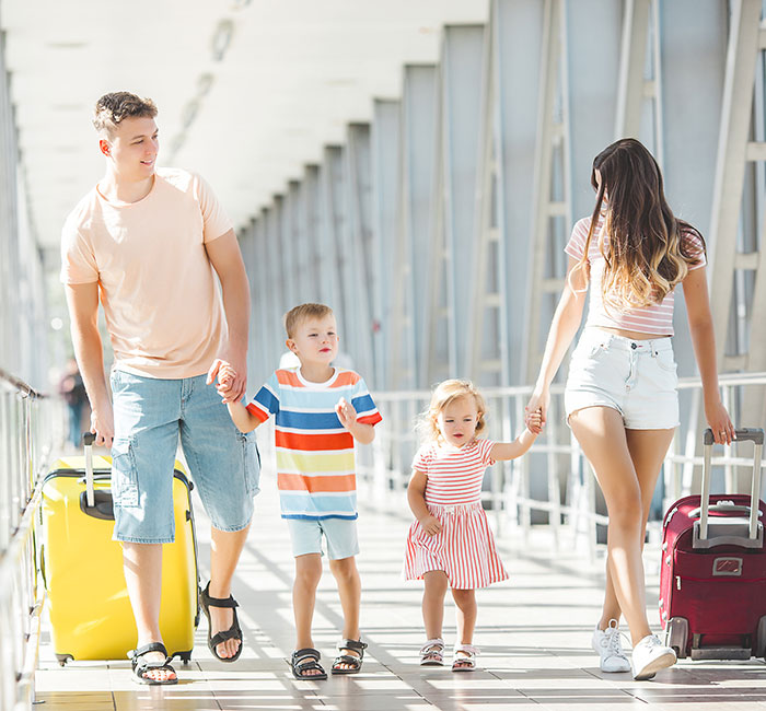Family vacation scene in a bright airport with parents and two kids, highlighting family-first values. Family vacation scene in a bright airport with parents and two kids, highlighting family-first values.