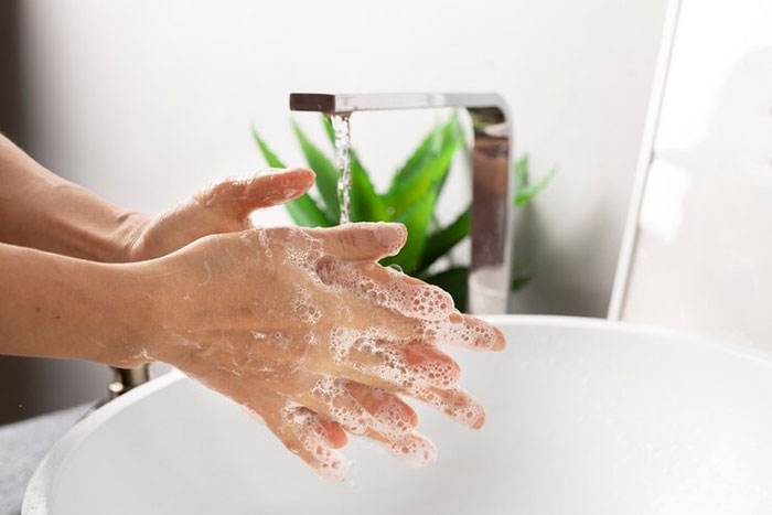 Close-up of hands lathered with soap under running water, emphasizing cleanliness and hygiene. Close-up of hands lathered with soap under running water, emphasizing cleanliness and hygiene.