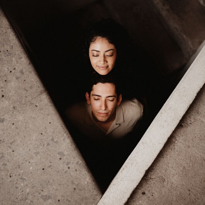 Couple with closed eyes in concrete setting, capturing a top engagement photo for 2025.