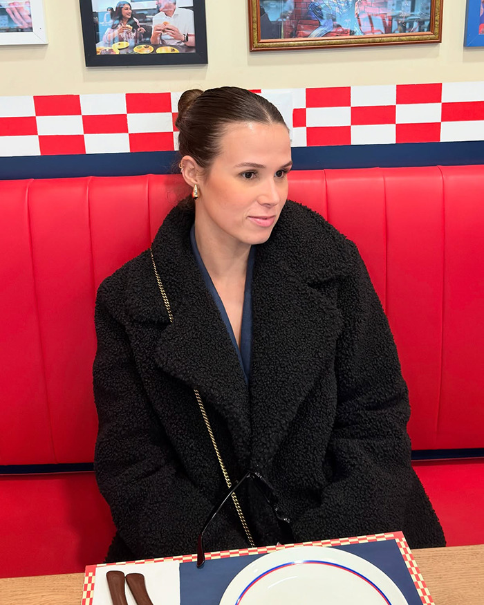 Person sitting in a restaurant booth wearing a black coat, associated with viral flyer story. Person sitting in a restaurant booth wearing a black coat, associated with viral flyer story.