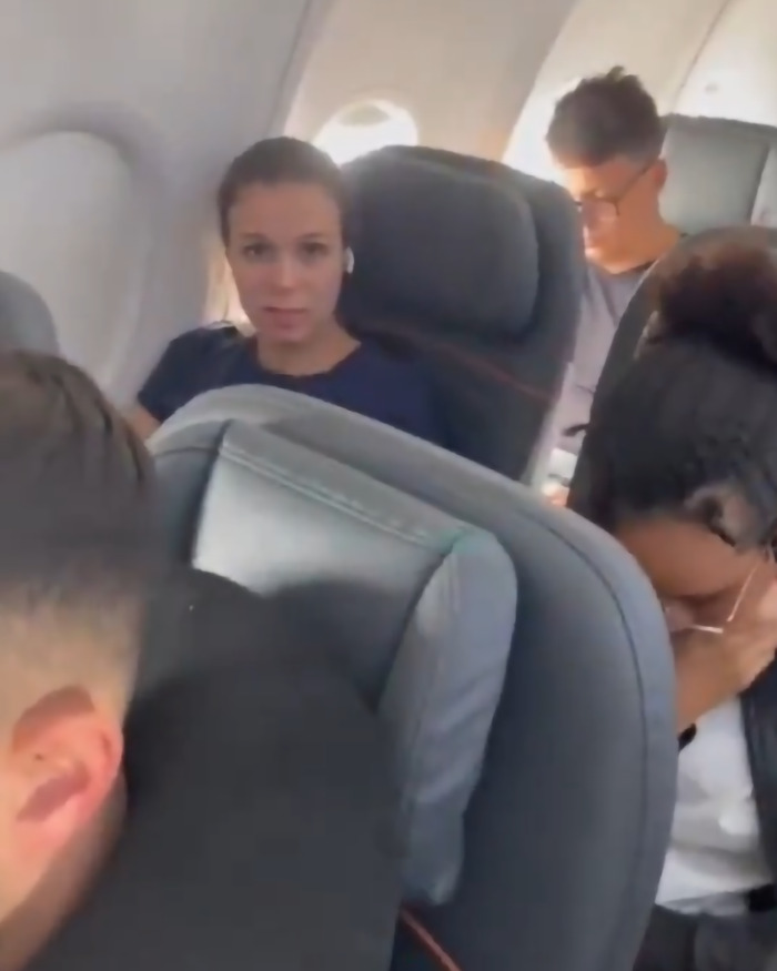 Passengers seated in an airplane, highlighting a viral flyer facing consequences for not giving up her seat. Passengers seated in an airplane, highlighting a viral flyer facing consequences for not giving up her seat.