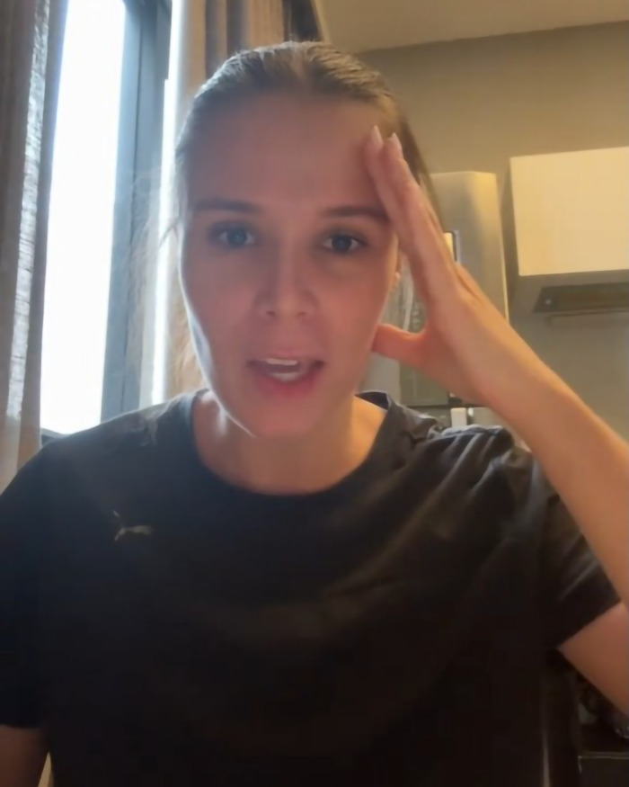 Woman discussing consequences after refusing to give up her seat, wearing a black shirt in a room with a kitchen background. Woman discussing consequences after refusing to give up her seat, wearing a black shirt in a room with a kitchen background.