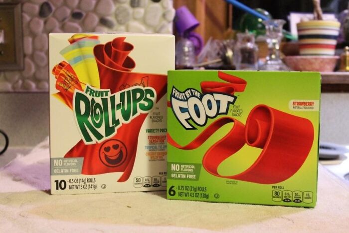 Boxes of Fruit Roll-Ups and Fruit by the Foot on a kitchen counter.